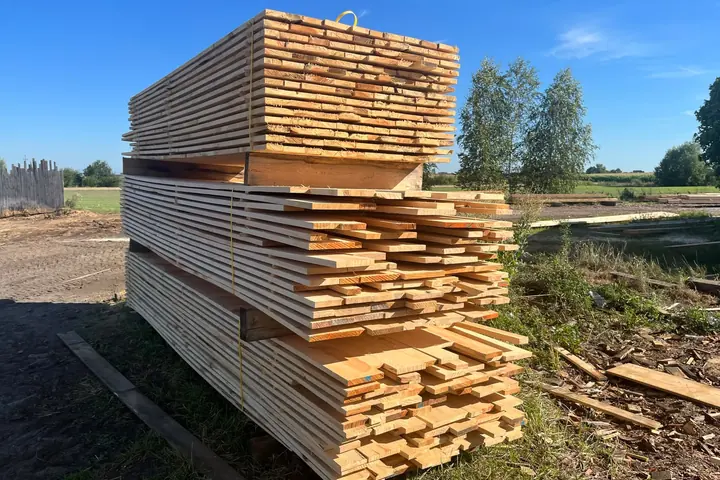Stos desek na placu tartaku, widoczne czoła